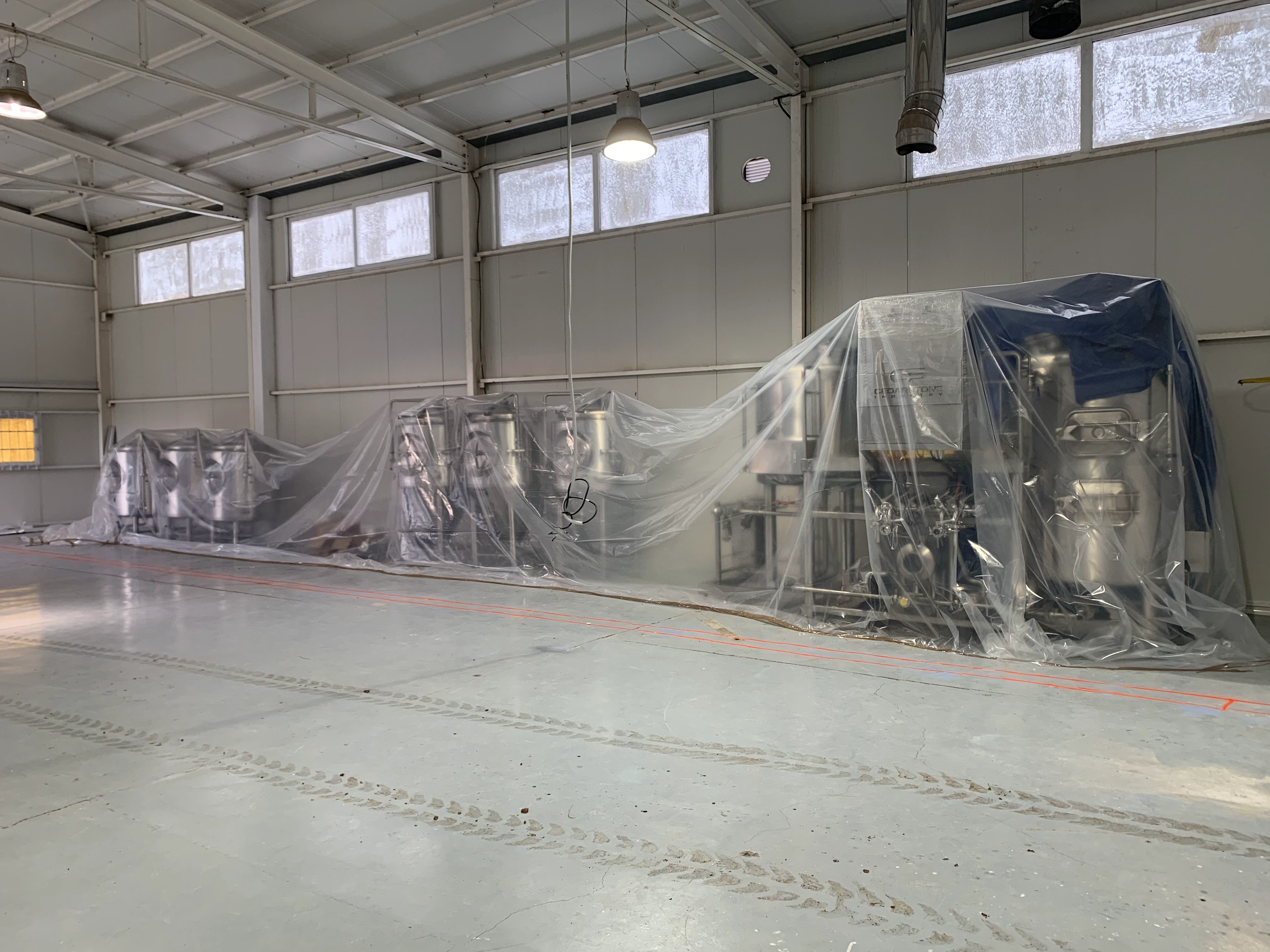 Stainless brewery tanks under protective sheeting at Forgtmenot Brewing, Greece