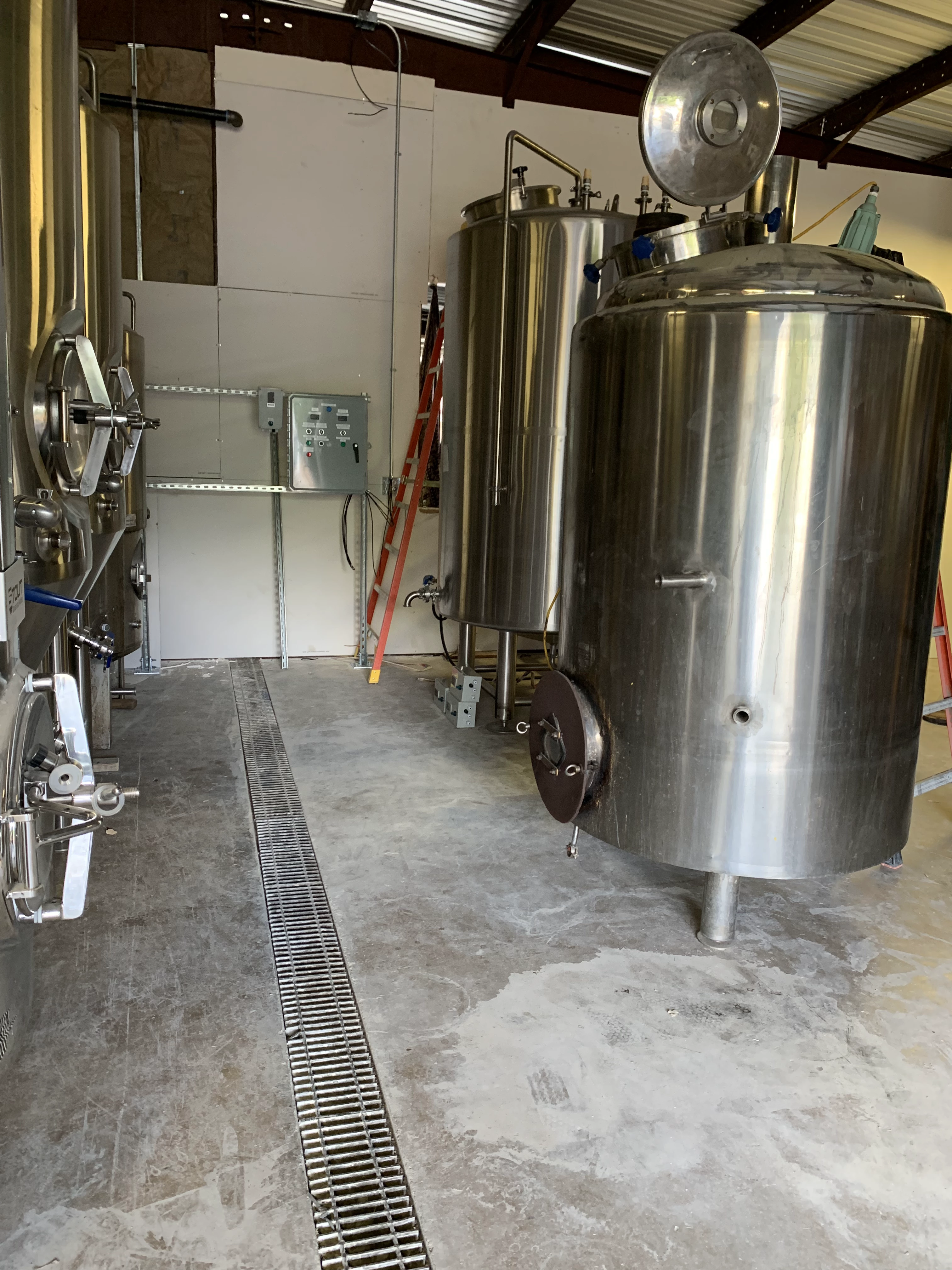 Stainless production vessels beside a central trench drain